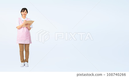 Woman wearing an apron holding a file, nursery teacher, care worker, cropped full-body photo Woman wearing an apron holding a file, nursery teacher, care worker, cropped full-body photo 108740266