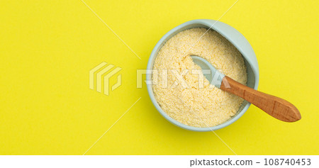 Baby porridge in a plate on a yellow background. Rice porridge for baby's growth and development. Strengthening immunity and health. Copy space for text 108740453