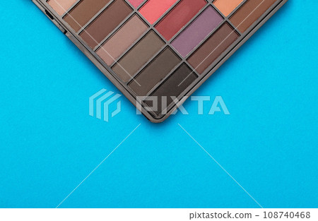 A set of modern eye shadows with powdery shades on a blue background. Soft texture and shading, brand, close-up. Copy space for text A set of modern eye shadows with powdery shades on a blue background. Soft texture and shading, brand, close-up. Copy space for text 108740468