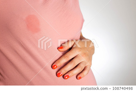 A soaked blouse from milk on the female breast of a nursing mother. Leak-proof bra pads, close-up. Copy space for text 108740498