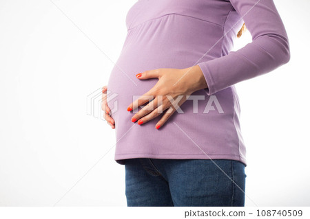 Pregnant girl holding her belly on a white background. Concept of intestinal and vaginal infections during pregnancy. Infection of the fetus through the placenta. Copy space for text Pregnant girl holding her belly on a white background. Concept of intestinal and vaginal infections during pregnancy. Infection of the fetus through the placenta. Copy space for text 108740509