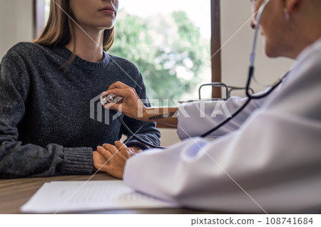 Doctor listens to heartbeat of patient middle age to check their heart rate 108741684