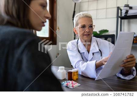 Senior female doctor are advise medication and vitamin daily to patient 108741782