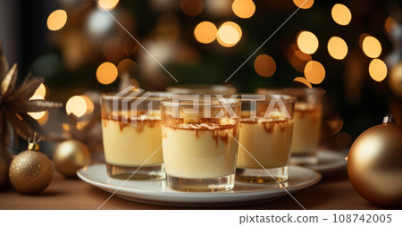 Delicious eggnog with cinnamon and nutmeg for the winter holidays. Traditional drink in glass, Christmas atmosphere. 108742005