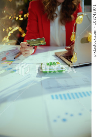 Business owner woman in green office with Christmas tree working 108742971