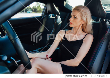 beautiful woman driver rides behind the wheel of a car beautiful woman driver rides behind the wheel of a car 108743015