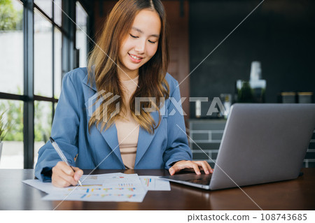 Business woman working with laptop computer she analyst financial advisor preparing statistic report studying documents, Businesswoman audit financial charts and graphs writing summary report data 108743685
