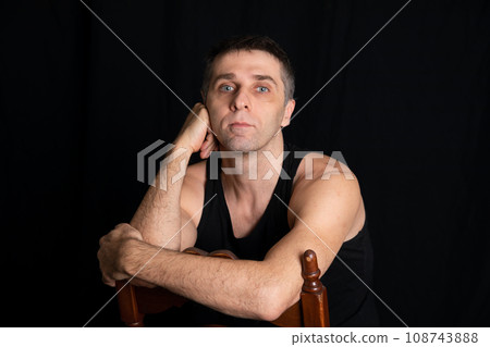 a man in dark clothes sits in a dark room a man in dark clothes sits in a dark room 108743888