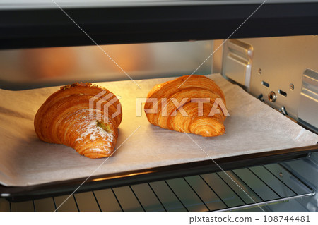 Modern mini electric oven with freshly baked croissants in kitchen Modern mini electric oven with freshly baked croissants in kitchen 108744481