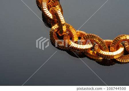 Golden chain necklace on black background with reflection Golden chain necklace on black background with reflection 108744500