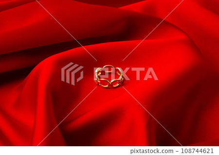 Golden ring on red silk background close up Golden ring on red silk background close up 108744621
