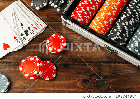Playing cards and chips in a case on wooden table 108744914