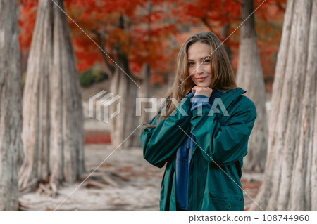 Young attractive woman walking down the park. Beautiful lady looking at the camera. Young attractive woman walking down the park. Beautiful lady looking at the camera. 108744960