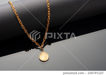 Golden chain necklace on black background with reflection Golden chain necklace on black background with reflection 108745187