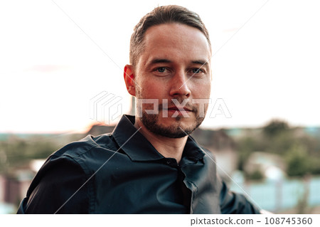 Portrait of handsome successful man standing outdoors 108745360