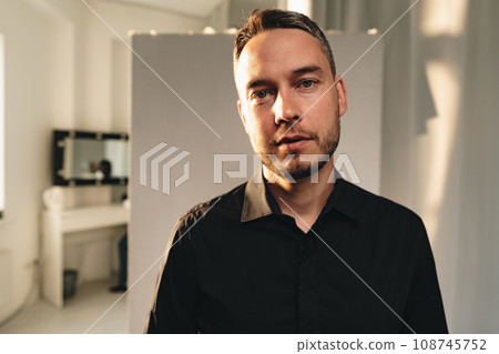 Portrait of a man in black shirt posing in photostudio Portrait of a man in black shirt posing in photostudio 108745752