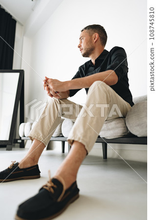 Portrait of a man in black shirt posing in photostudio 108745810