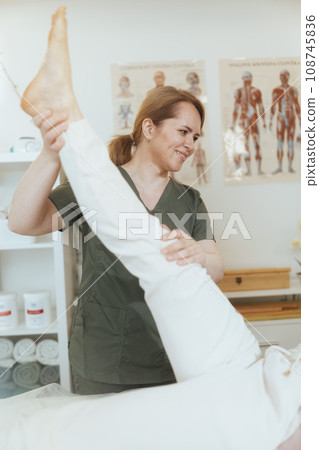 female therapist in massage cabinet conducting examination 108745836