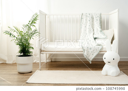 Baby wooden crib and toy rabbit in nursery room Baby wooden crib and toy rabbit in nursery room 108745998