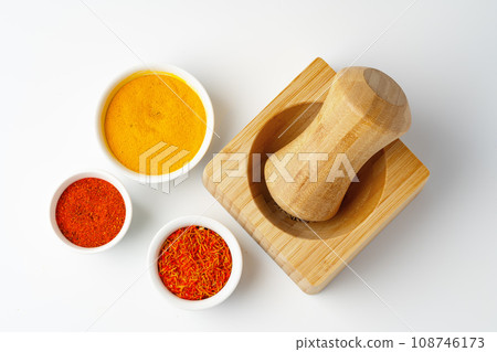 Wooden mortar with spices on white background Wooden mortar with spices on white background 108746173