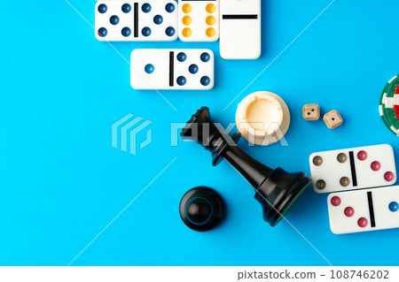 Chess figures and domino tiles on blue background Chess figures and domino tiles on blue background 108746202