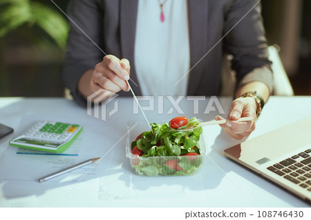 Modern business woman in green office eating salad 108746430