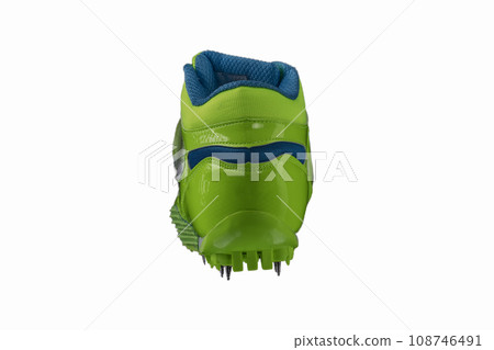 Green glossy sneaker with spikes on a white background. Sport shoes. 108746491