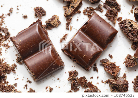 Large pieces of chocolate with slices. Crushed chocolate on a white background 108746522