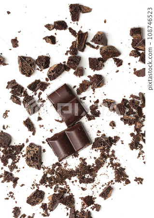 Vertical chocolate chips with slices. Crushed chocolate on a white background 108746523