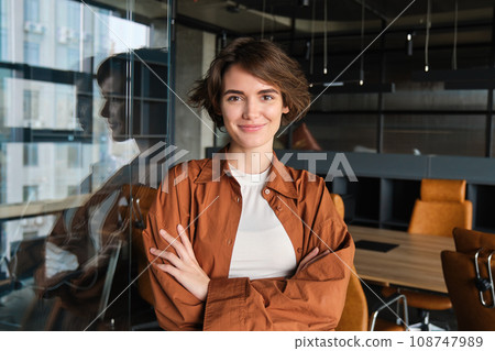 Portrait of young confident woman, start-up manager in office, posing with confidence, looking self-assured, wearing casual, informal clothes Portrait of young confident woman, start-up manager in office, posing with confidence, looking self-assured, wearing casual, informal clothes 108747989