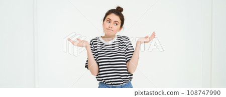 Image of confused brunette girl shrugging shoulders, looks puzzled, isolated over white background Image of confused brunette girl shrugging shoulders, looks puzzled, isolated over white background 108747990
