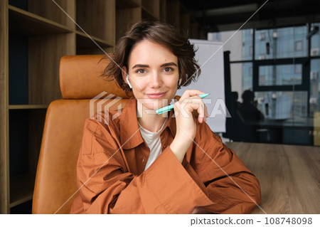 Portrait of woman writing down notes, working with documents in office 108748098
