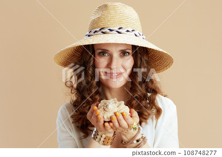 smiling elegant woman in blouse and shorts on beige smiling elegant woman in blouse and shorts on beige 108748277