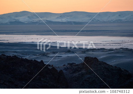 Highland river valley with morning fog on a background of snow covered mountains and glaciers with beautiful sunrise. in the steppe near the mountains during the autumn. Altai region. 108748312