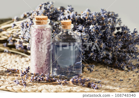 lavender oil and salt in glass bottle on background of dry lavender flowers. bottle of essential Herbal oil or infused water. aromatherapy spa massage concept. Natural cosmetics for the body. lavender oil and salt in glass bottle on background of dry lavender flowers. bottle of essential Herbal oil or infused water. aromatherapy spa massage concept. Natural cosmetics for the body. 108748340