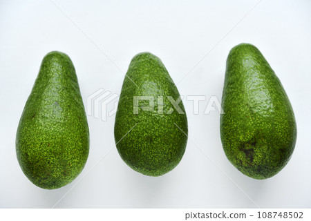 Ripe juicy avocado fruit on a white background. Vegetarian vegetables. Green fruits. Ripe juicy avocado fruit on a white background. Vegetarian vegetables. Green fruits. 108748502