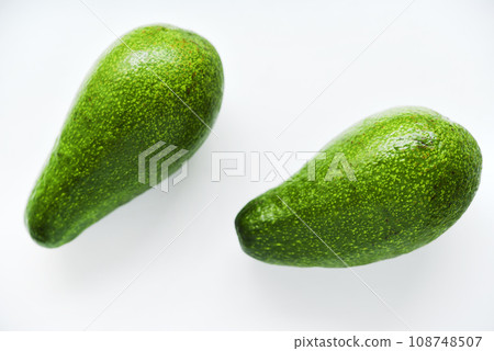 Ripe juicy avocado fruit on a white background. Vegetarian vegetables. Green fruits. Ripe juicy avocado fruit on a white background. Vegetarian vegetables. Green fruits. 108748507
