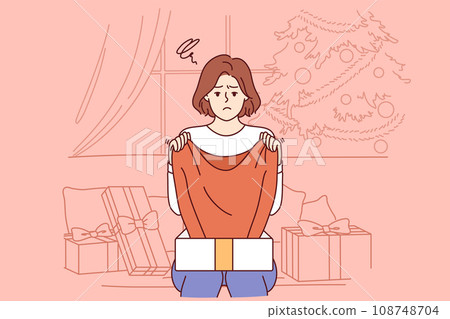 Sad woman upset by christmas gift, sitting on sofa among giftboxes near new year tree Sad woman upset by christmas gift, sitting on sofa among giftboxes near new year tree 108748704