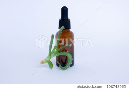 A brown bottle with a pipette is used in cosmetology, next to aloe leaves A brown bottle with a pipette is used in cosmetology, next to aloe leaves 108748965