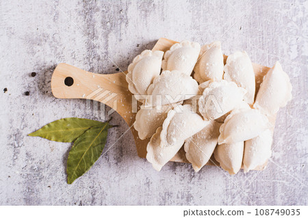 Close up of homemade raw dumplings with meat on a cutting board on the table top view 108749035
