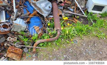 Scrap yard with old iron and sheet metal from cars, appliances, shelves, tin rails and corrugated metal roofing. 108749084