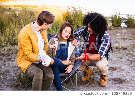 Compassionate Trek: Multicultural Friends Aid Injured Asian Hiker 108749339