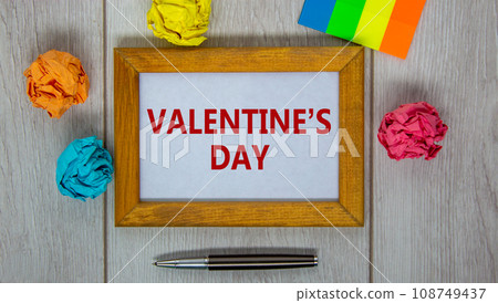 February 14 valentines day symbol. Wooden frame with words 'Valentines day'. Pen, colored paper. Beautiful wooden background, copy space. Happy Valentines day concept. 108749437
