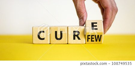 Curfew and cure symbol. Businessman turns a cube and changes the word 'curfew' to 'cure'. Beautiful white and yellow background. Business, curfew and cure concept. Copy space. 108749535
