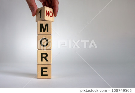 1 or no more symbol. Hand turns a cube and changes the words '1 more' to 'no more'. Beautiful white background. Business concept. Copy space. 108749565