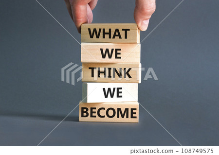 We become or think symbol. Concept word What we think We become on wooden block. Beautiful grey table grey background. Businessman hand. Business we become or think concept. Copy space. 108749575