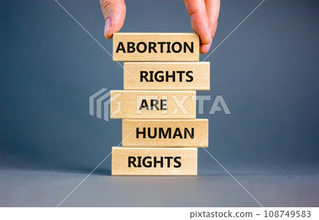 Abortion rights symbol. Concept words Abortion rights are human rights on wooden blocks. Businessman hand. Beautiful grey table grey background. Business medical abortion rights concept. Copy space. 108749583