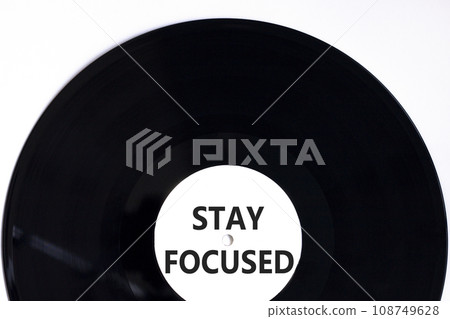 Stay focused symbol. Concept words Stay focused on beautiful black vinyl disk on a beautiful white table white background. Business, support, motivation, psychological stay focused concept. Copy space 108749628