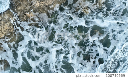Aerial view of sea waves hitting the rocks with drone 108750669
