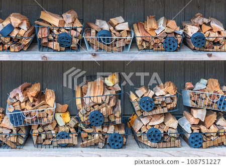 [Material] A basket containing charcoal and logs placed on a camp fireplace shelf. 108751227